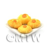 Miniature Orange Iced Flower Biscuits On A Square Plate