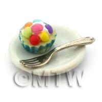 Miniature Smartie Topped Cupcake In A Blue Paper Cup On A Plate With A Fork