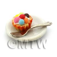 Miniature Smartie Topped Cupcake In An Orange Cup On A Plate With A Fork